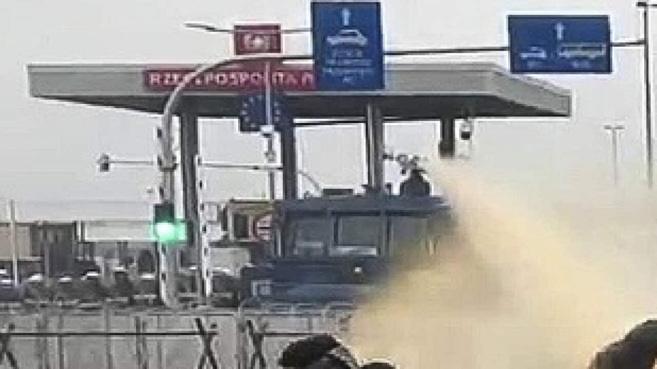Polish servicemen use a water cannon during clashes between migrants gathering at the checkpoint "Kuznitsa" at the Belarus-Poland border near Grodno, Belarus, on Tuesday, Nov. 16, 2021