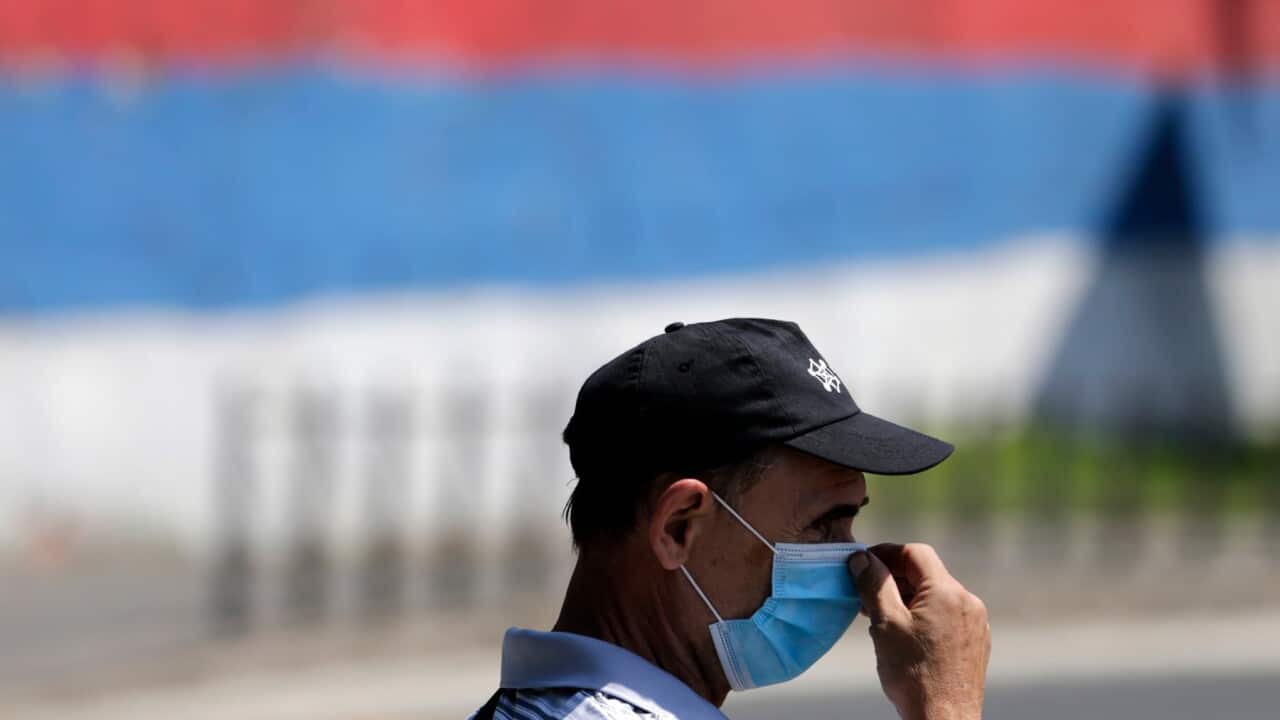 A man adjusts his protective face mask while waiting for a bus in Belgrade, Serbia, 23 July 2020. Countries around the world are taking measures to stem the spread of the SARS-CoV-2 coronavirus, which causes the COVID-19 disease.