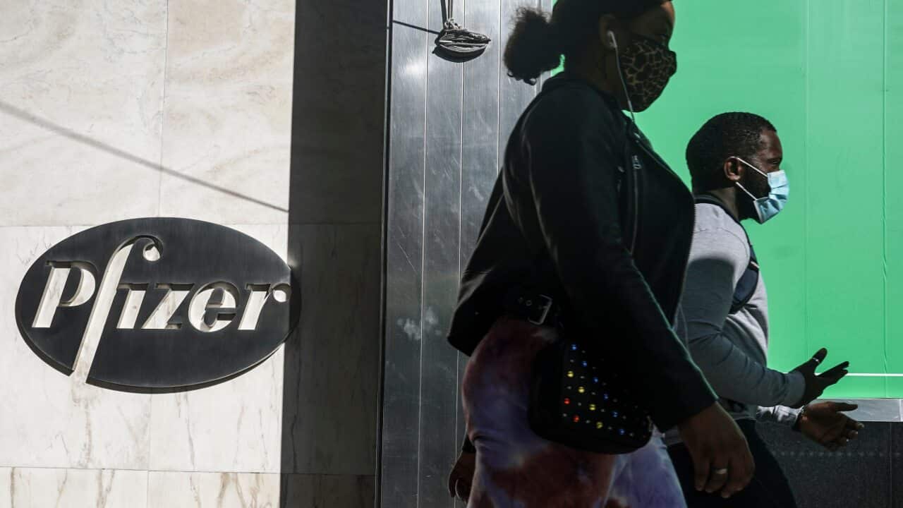 Pedestrians walk past Pfizer world headquarters, Monday 9 November, 2020, in New York.