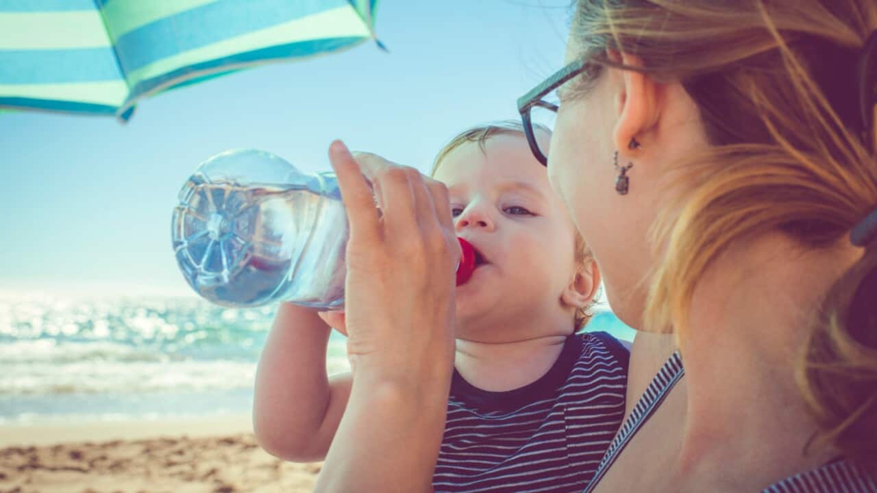 Baby drinking water on beach (Getty Images.ArtMarie)