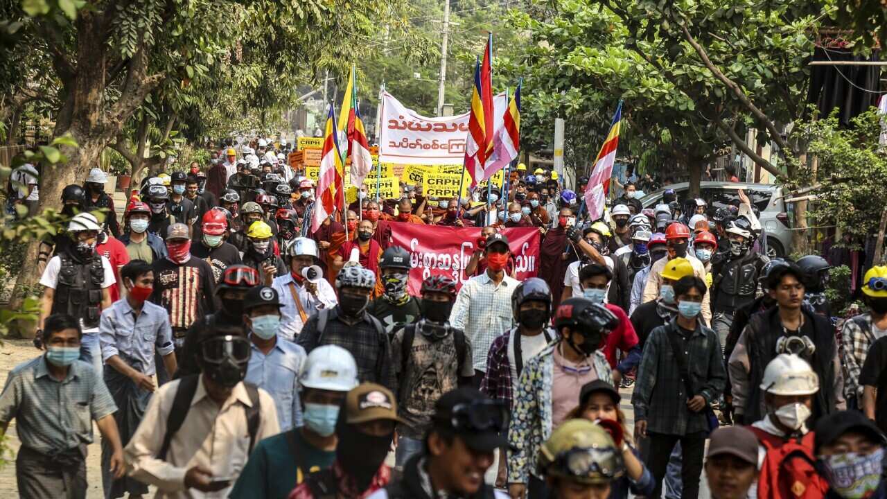 Demonstrators carry placards during a protest against the military coup in Myanmar
