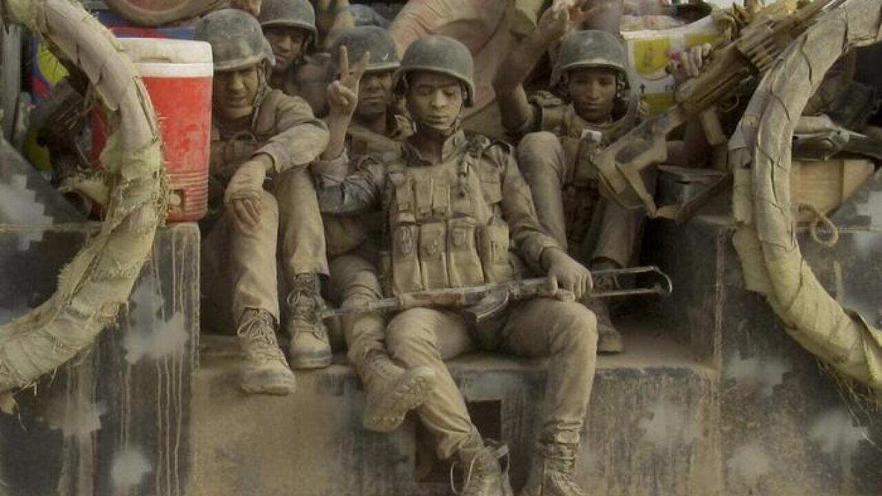 Iraqi Federal police covered in dust arrive to join the forces surrounding Fallujah