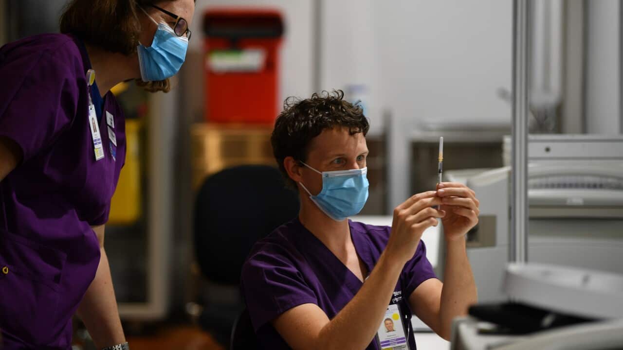 A healthcare worker is seen handling a AstraZeneca covid19 vaccination inside of vaccination centre