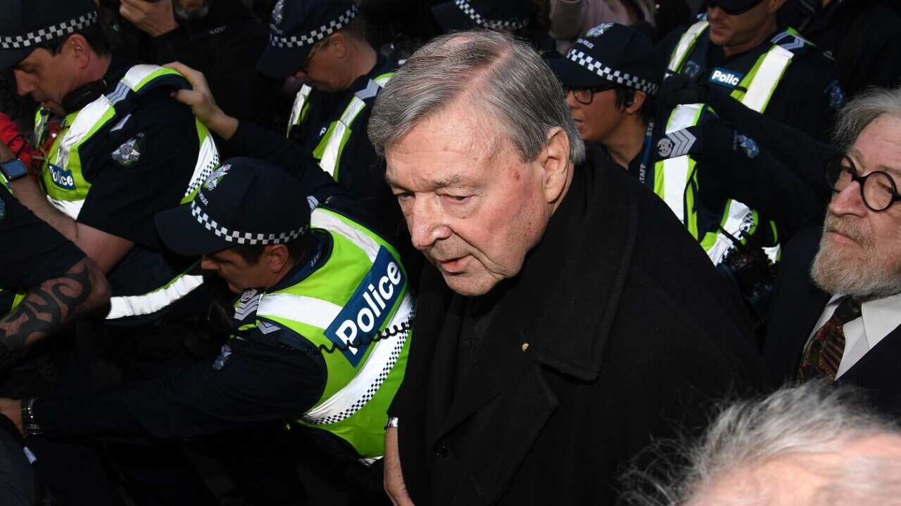 Cardinal George Pell escorted by police arrives at the Melbourne Magistrates Court in Melbourne, Wednesday, July 26, 2017.
