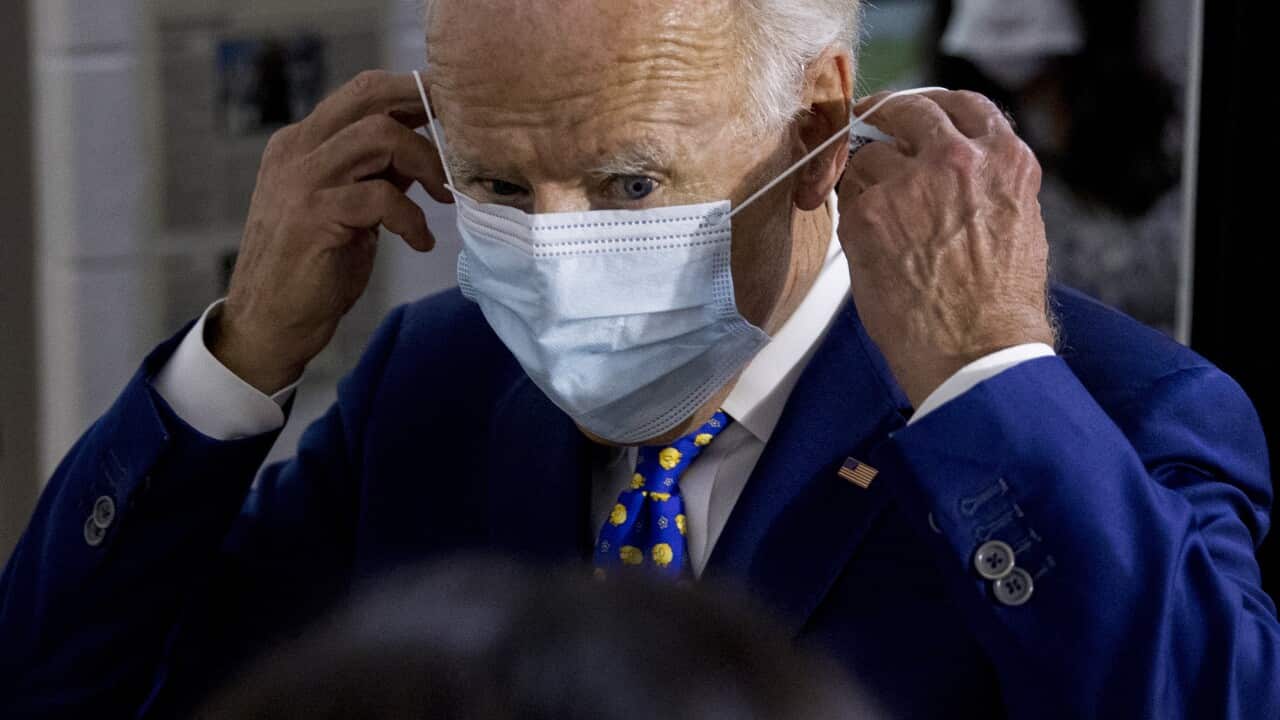 Democratic presidential candidate former Vice President Joe Biden puts on his mask.