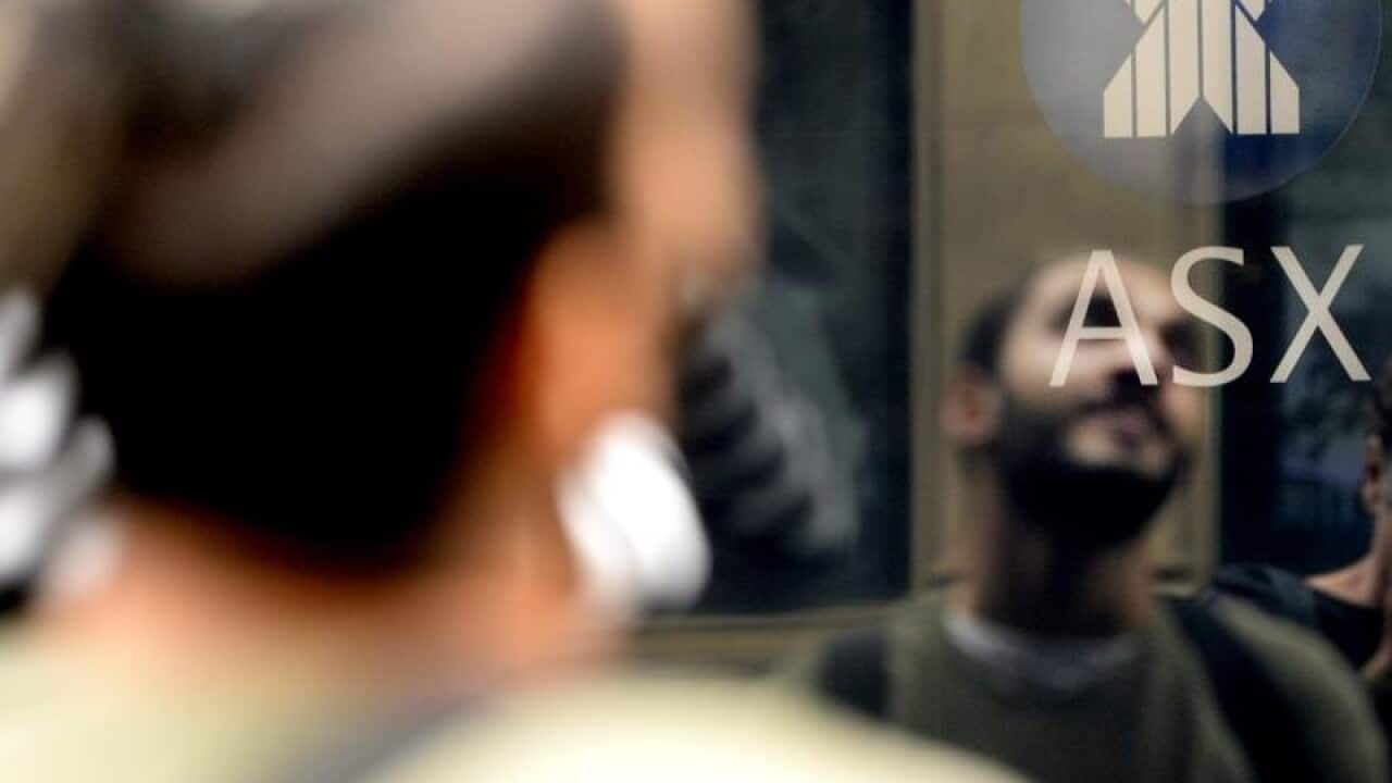 Man reflected on the ASX trading board.