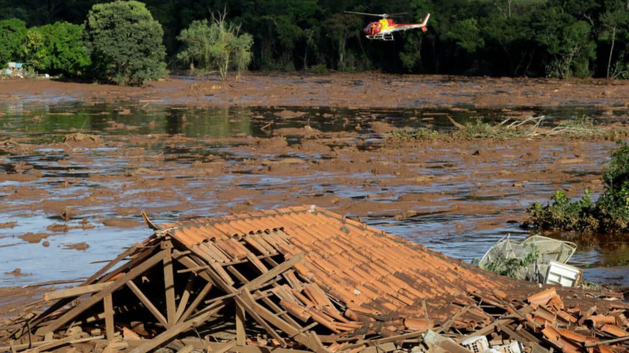 Rescue workers in a helicopter search a flooded area after a dam collapsed in Brumadinho, Brazil