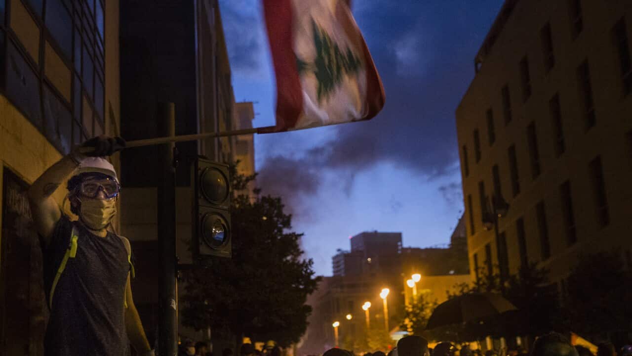 A protester waves the Lebanese flag near Martyrs' Square on 9 August, 2020 in Beirut, Lebanon.