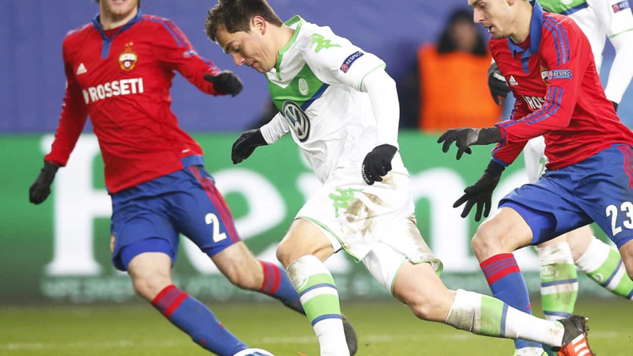 Wolfsburg's Marcel Schaefer (C) in action against CSKA Moscow players.