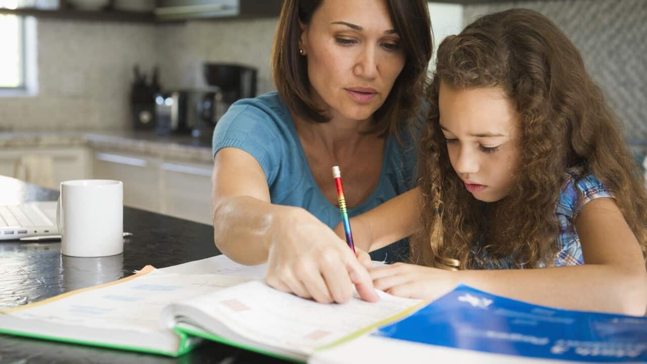 Woman helping daughter with her studies