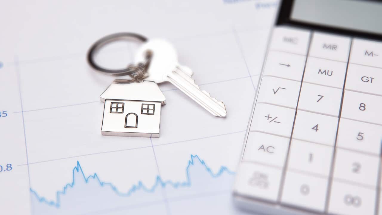 A key on a keyring with a house, a graph and a calculator.