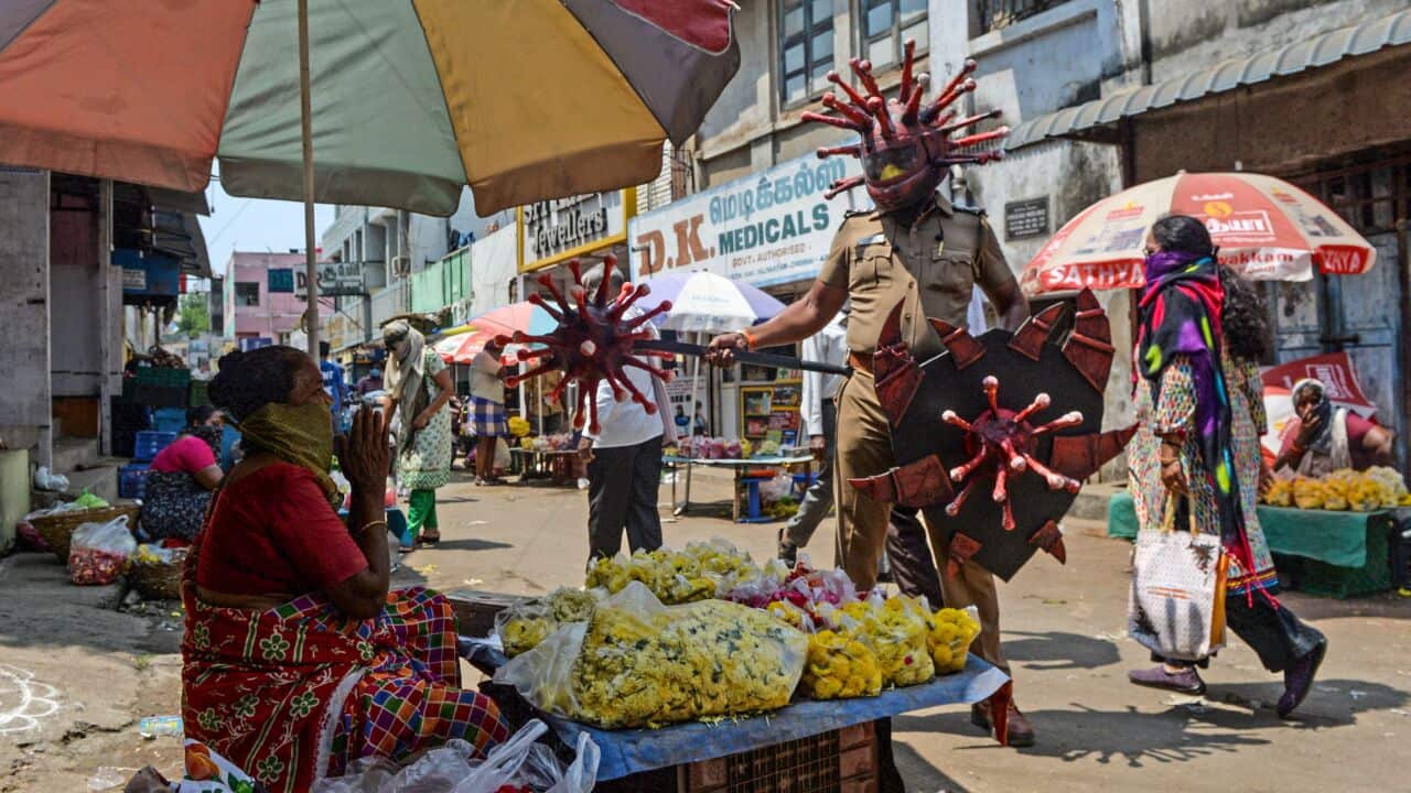 An Indian policeman wears a coronavirus-themed outfit composed of helmet, mace and shield, to raise awareness about social distancing.