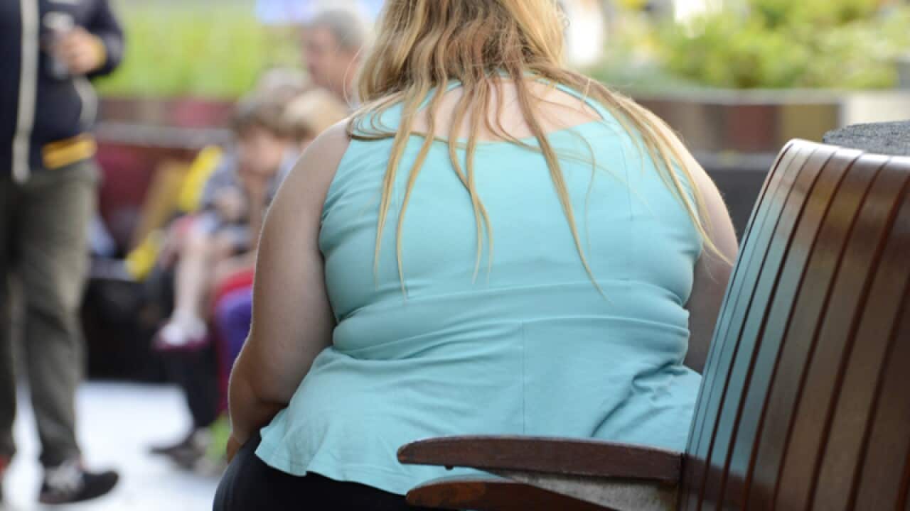 An obese woman sits on a bench