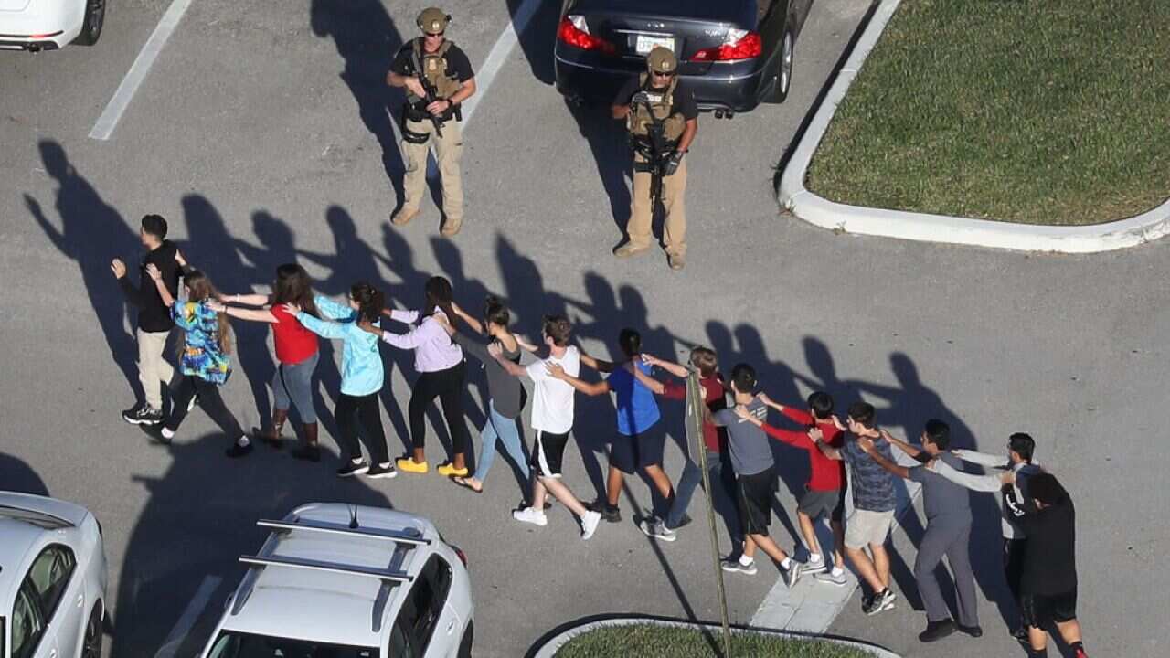 People are brought out of the Marjory Stoneman Douglas High School after a shooting at the Florida school.