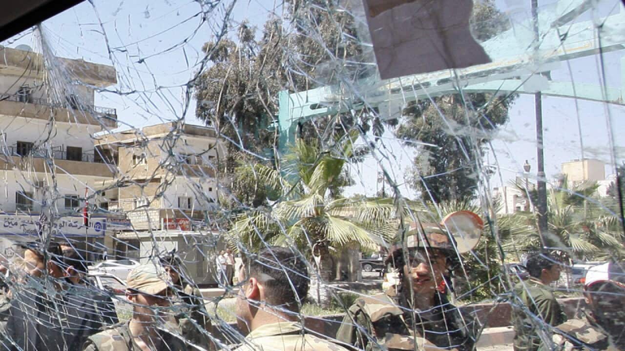 Syrian army soldiers, are seen through a damaged military truck