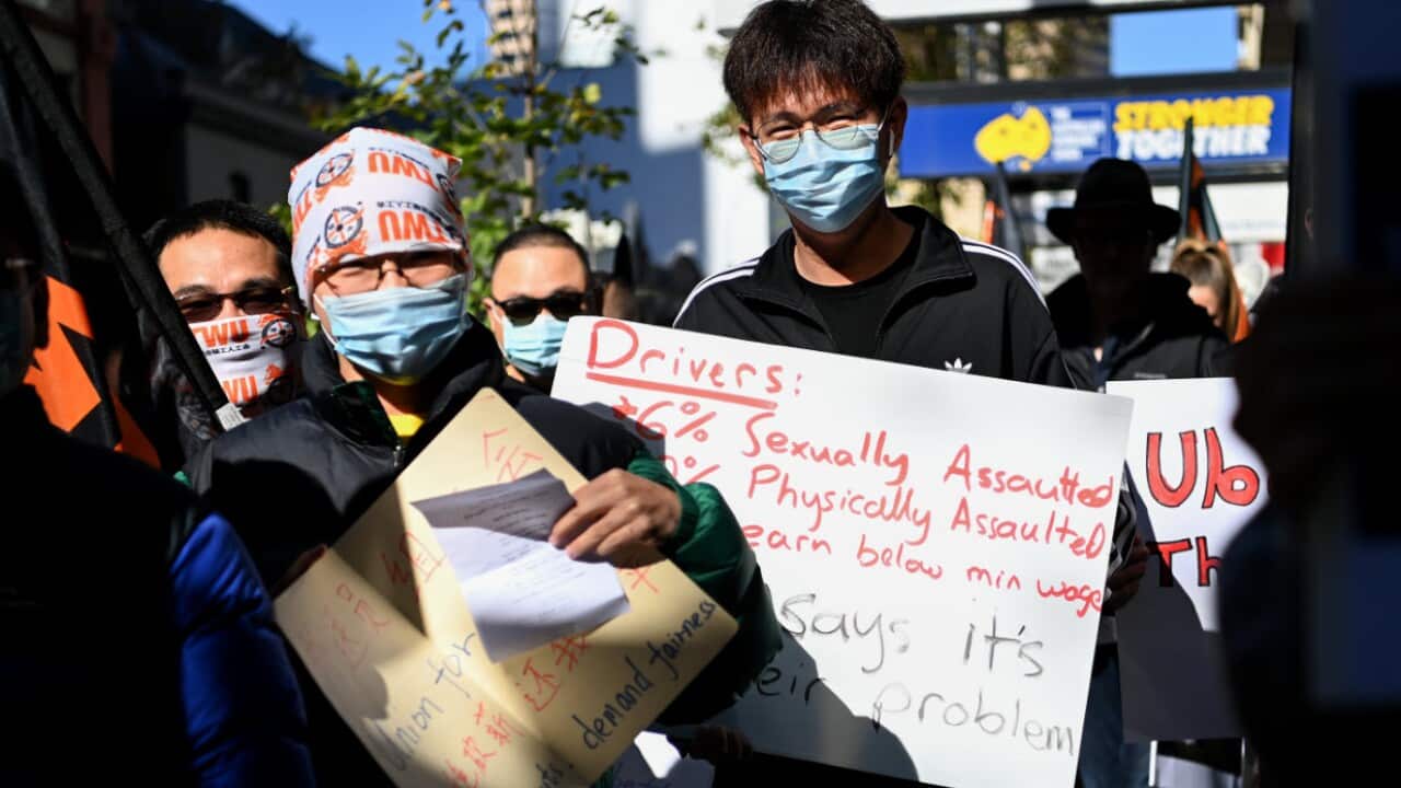 Protesters hold placards during a protest for the rights of food delivery workers in Sydney, Wednesday, 19 May, 2021.