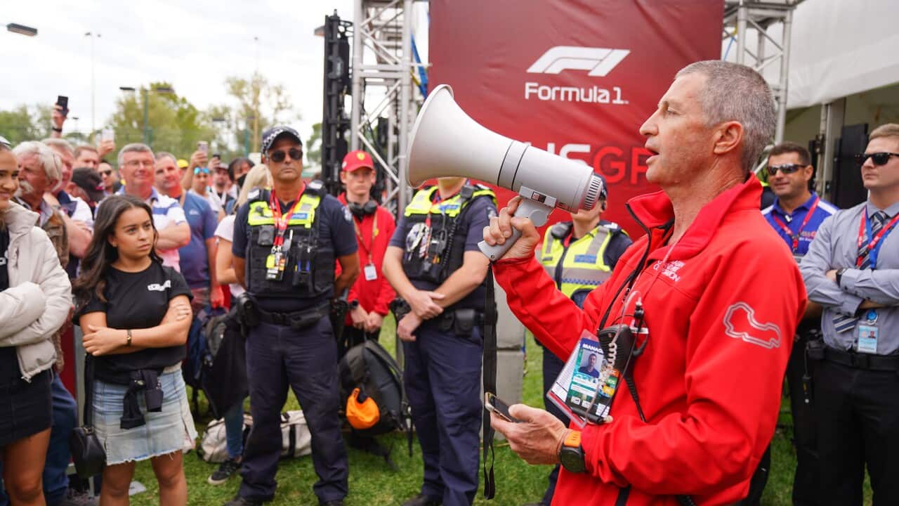 An Australian Grand Prix official tells the crowd of spectators waiting at the gate that the event has been cancelled.