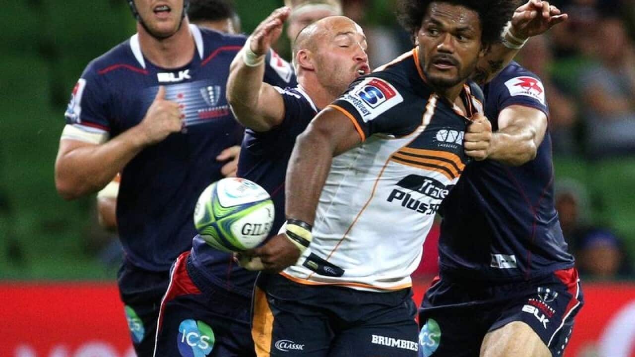 Henry Speight of the Brumbies passes the ball during a rugby match.