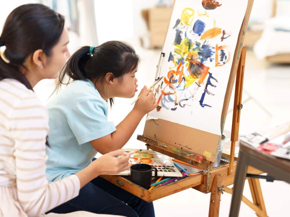 Mother teaching child practice painting for a hobby