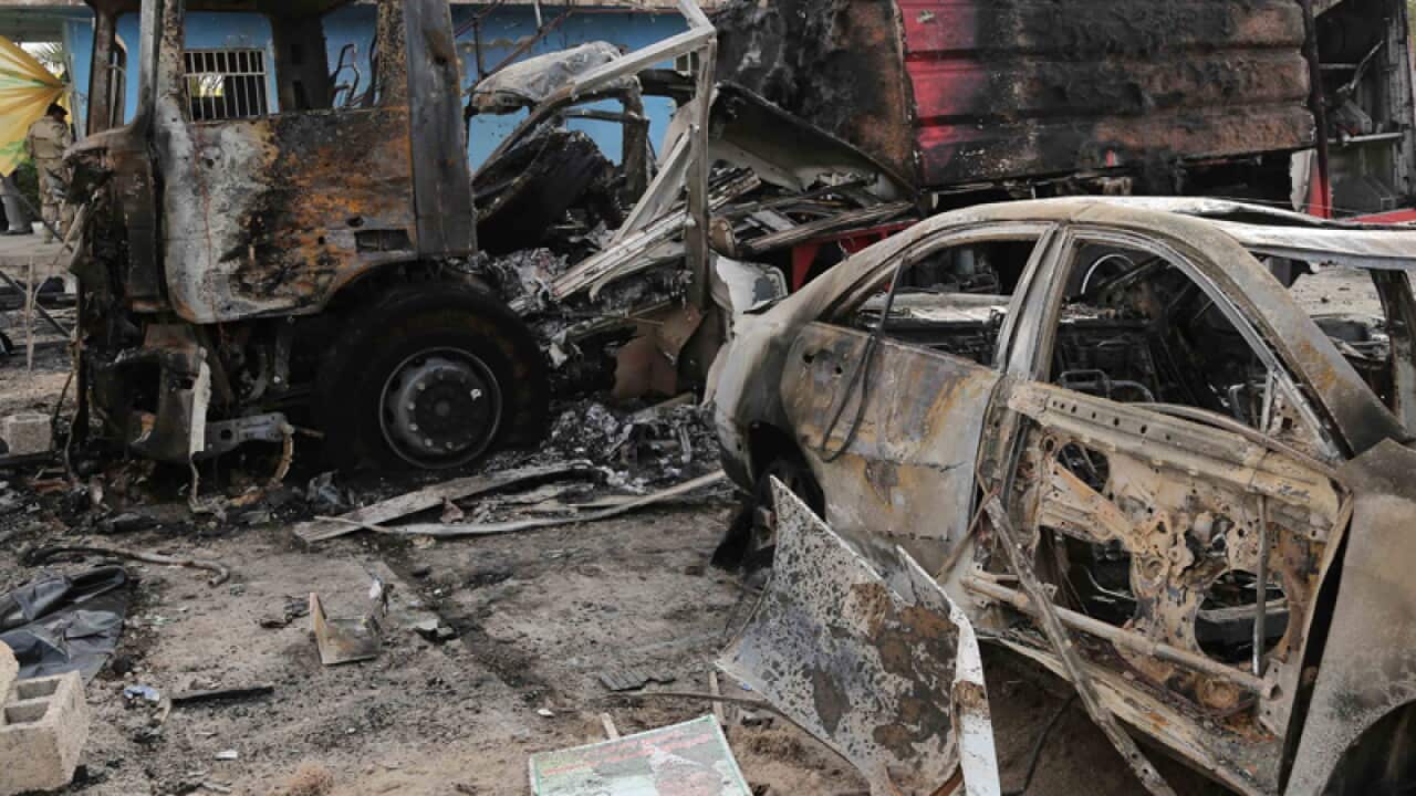Burned vehicles remain in the Industrial Stadium after a bombing.