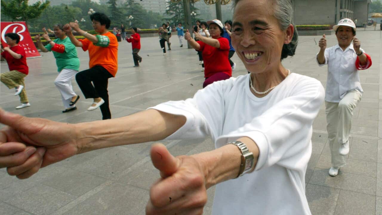An elderly Chinese lady exercising with others at a park in Beijing, China, Wednesday, May 21, 2003. Fitness has taken on a new significance as Beijingers are encouraged to stay healthy inorder to keep SARS away. (AP Photo/Ng Han Guan)