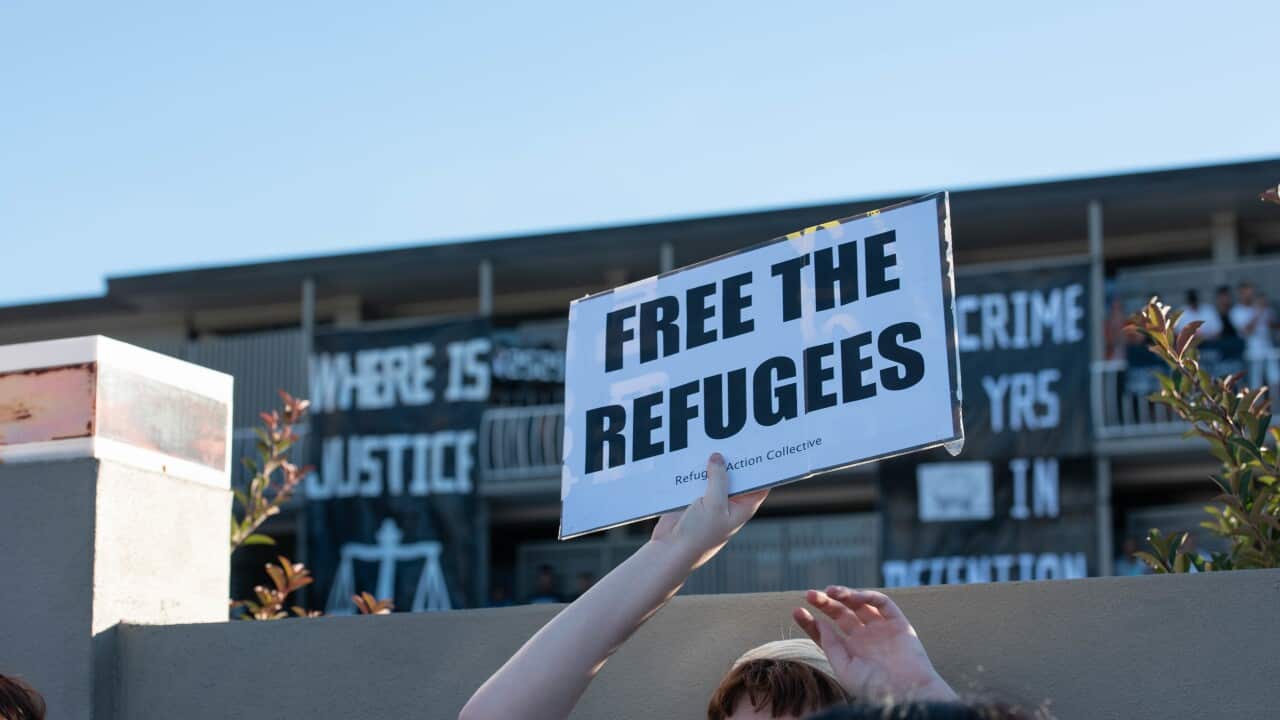 A protester holds a sign stating 'Free the refugees' during a protest outside Kangaroo Point Hotel in Brisbane.