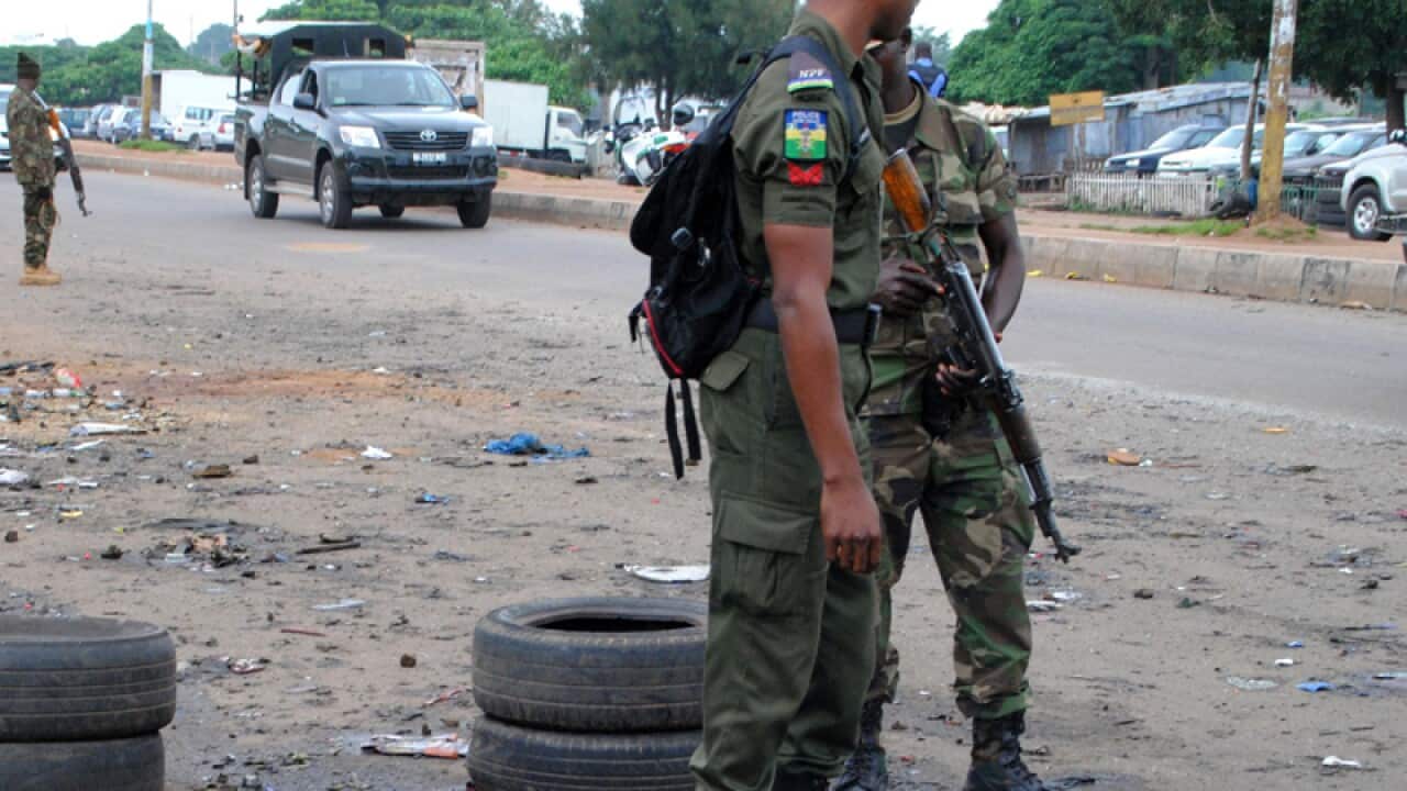 Police officers stand next to a checkpoint, Nigeria.