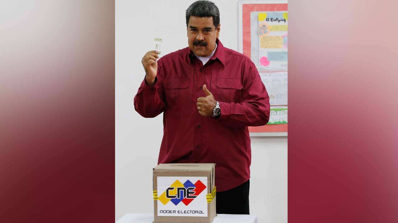 Venezuela's President Nicolas Maudro show his ballot before voting during presidential elections in Caracas.