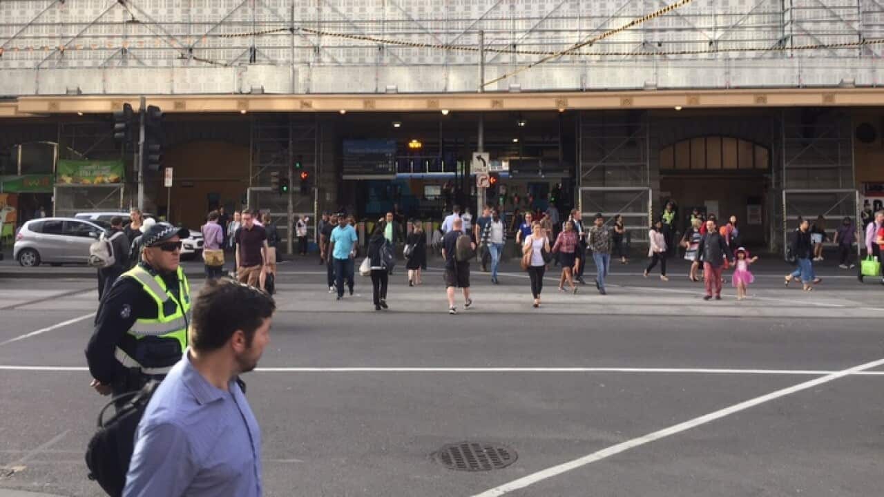 Pedestrians on the corner of Flinders and Elizabeth Streets in Melbourne