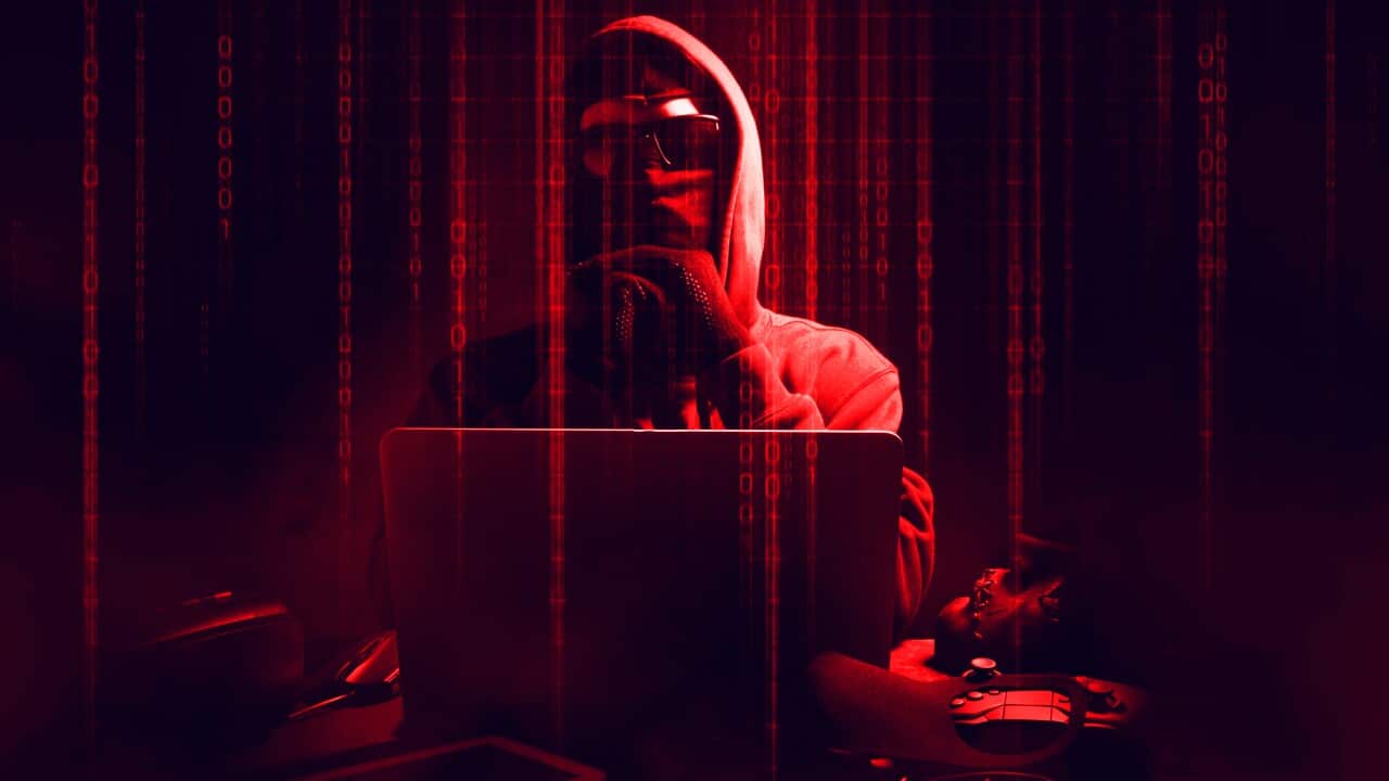 Digital Composite Image Of Male Hacker Using Laptop With Binary Codes In Darkroom