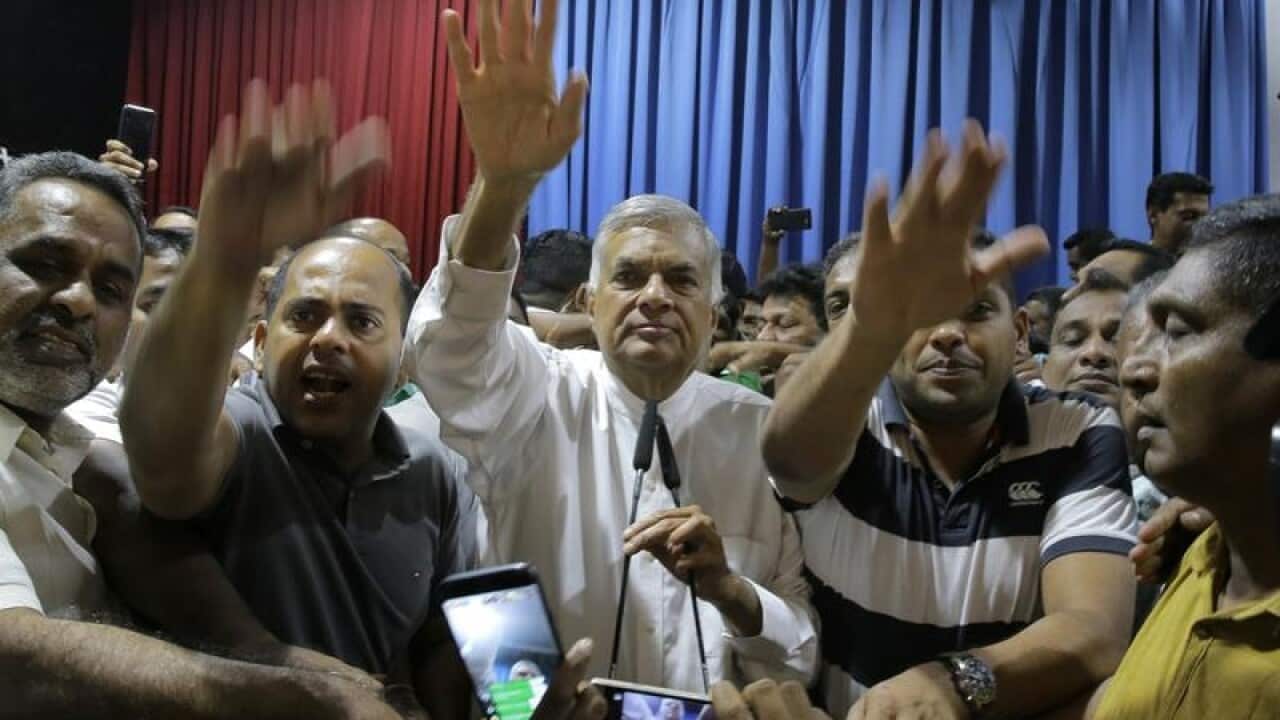 Sri Lanka's sacked PM Ranil Wickeremesinghe (c) with his supporters