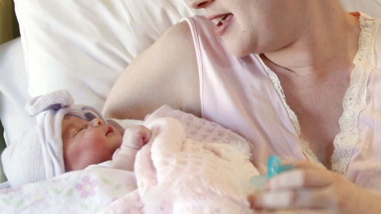 A mother cradles her newborn baby.