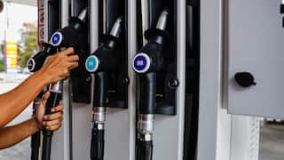 A car's petrol tank and a petrol price board