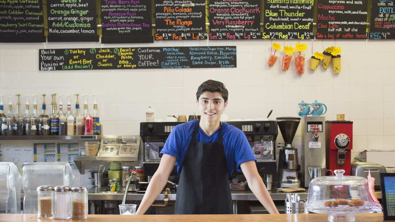 Mixed race teenage boy working in cafe