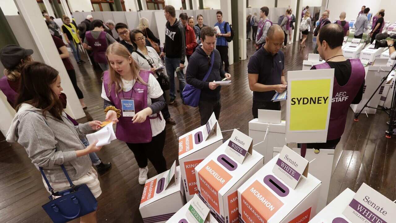 Voters cast their ballots at the Town Hall in Sydney, Australia, in a federal election, Saturday, May 18, 2019.
