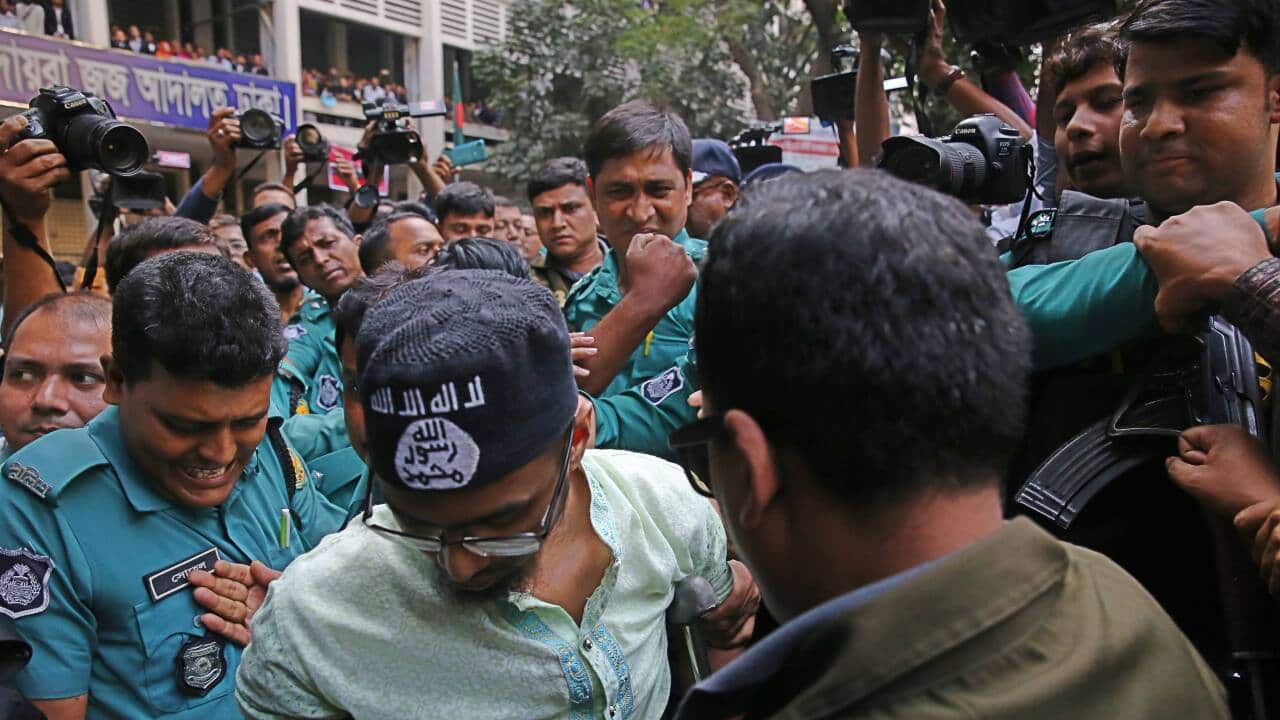 Police escort a member of a banned militant group after he was sentenced to death.