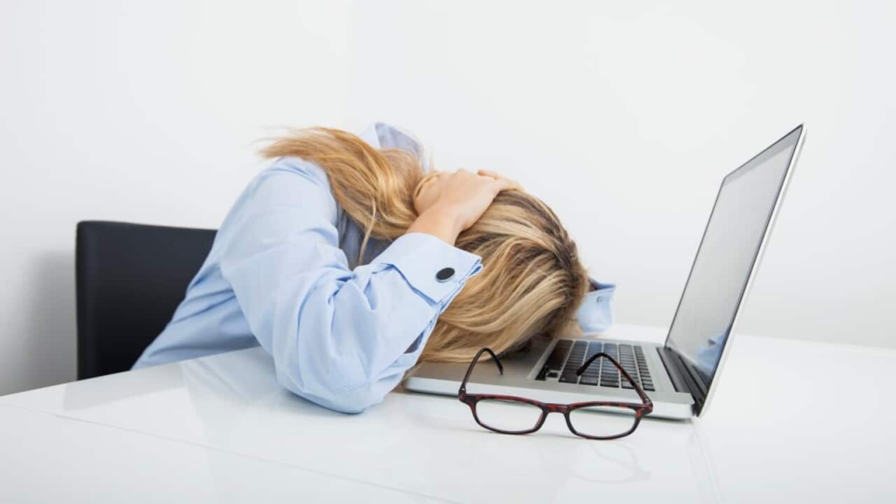 Bsinesswoman resting head on laptop in office