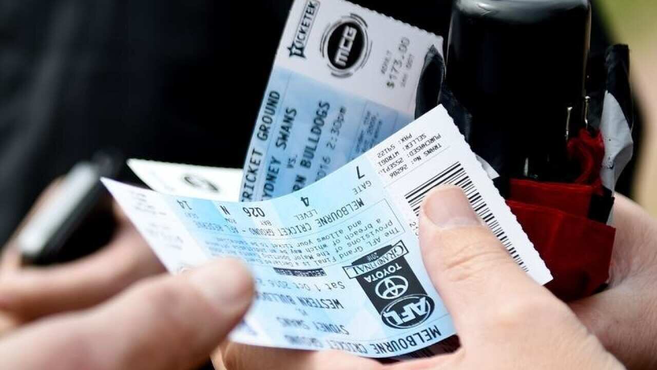 Fans hold their tickets