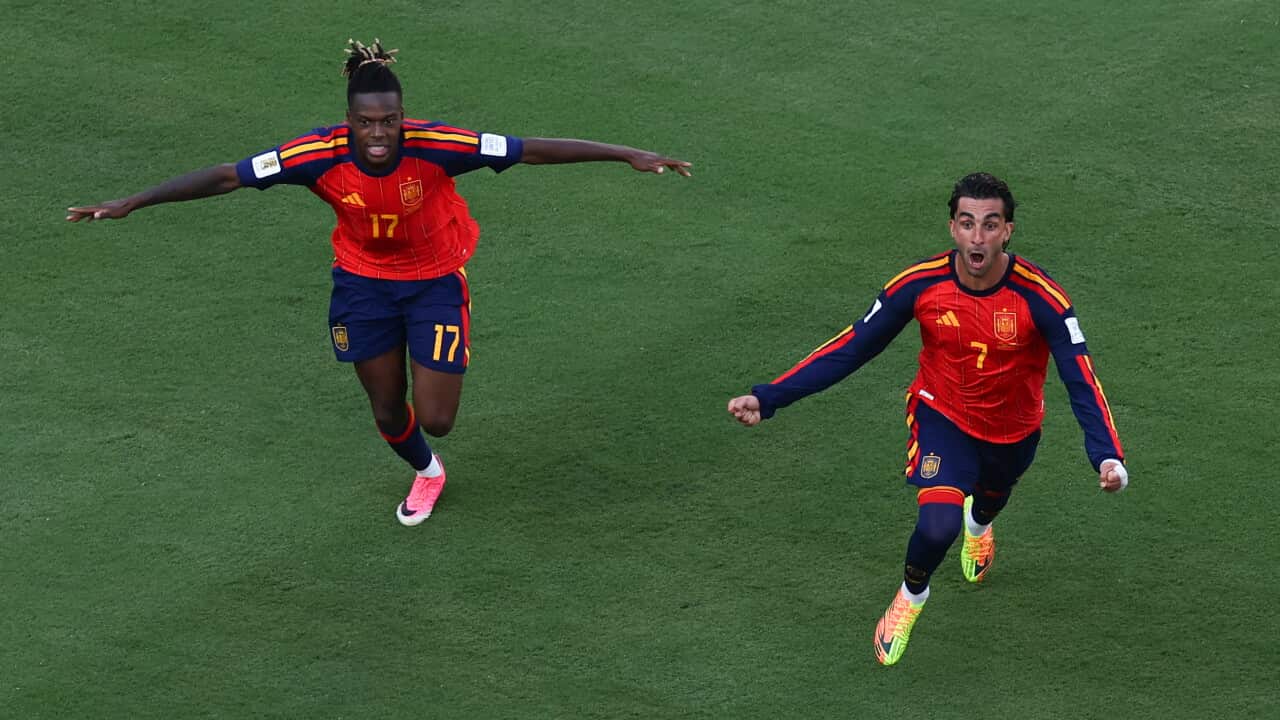 Nico Williams and Ferran Torres, both wearing red uniforms, celebrating on a football pitch.