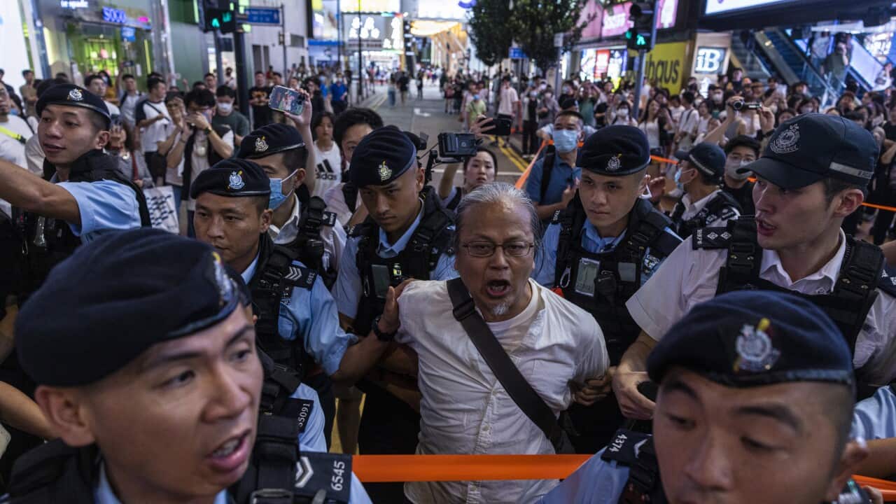 Police officers take away a member of the public in the Causeway Bay area on the eve of the 34th anniversary of China's Tiananmen Square massacre, in Hong Kong. Source: AP / Louise Delmotte/AP