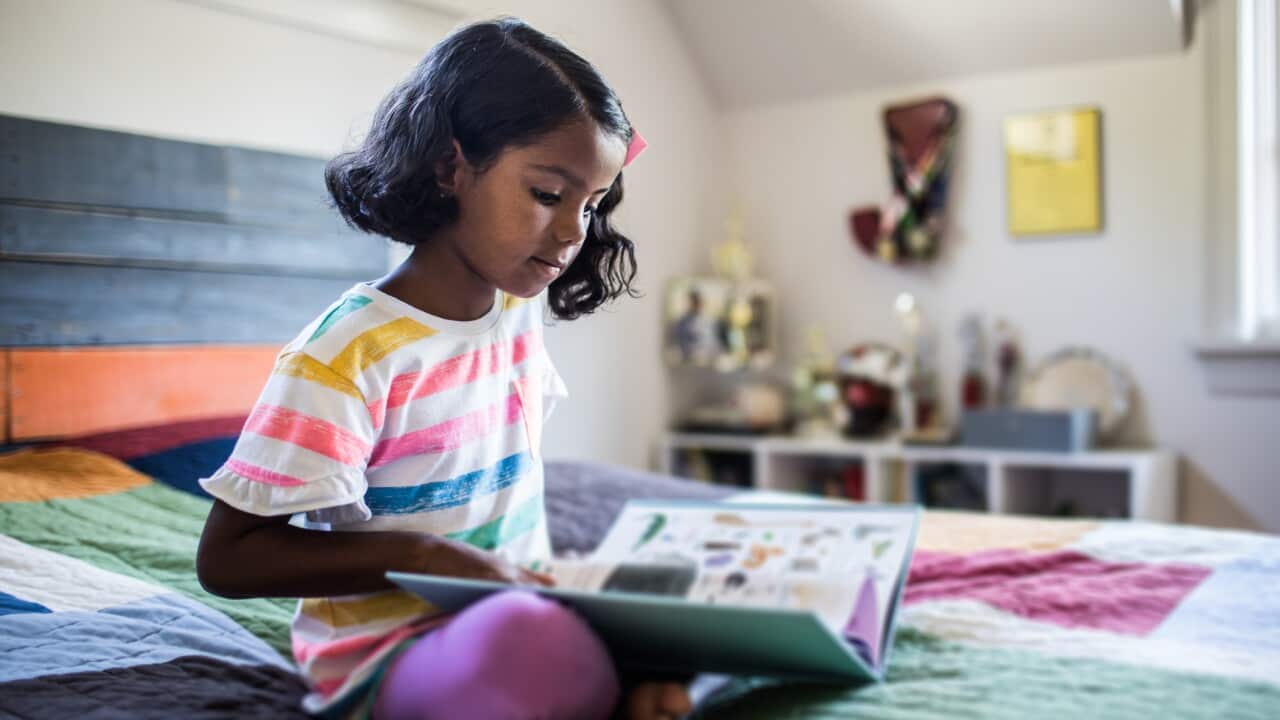 Girl reading book on her bed