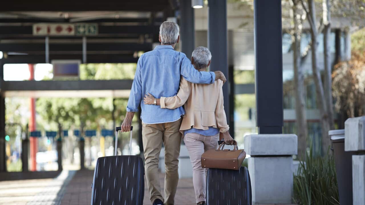Senior couple walking together on public transport station