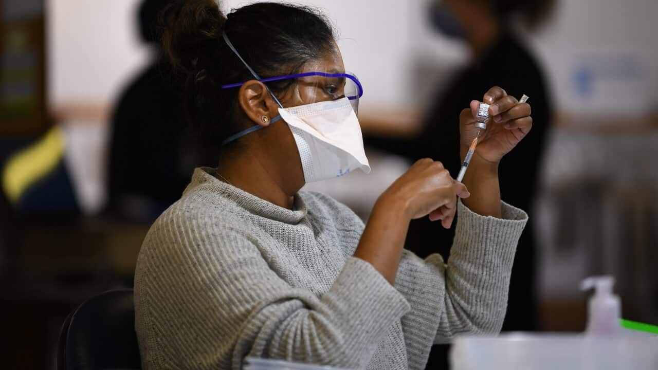 یکی از کارکنان بخش سلامنت ویکتوریا در حال آماده کردن یک واکسن کووید-۱۹