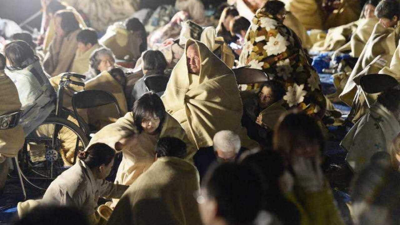 Residents take shelter outside the town hall of Mashiki, near Kumamoto city, southern Japan, after the earthquake early Friday, April 15, 2016.