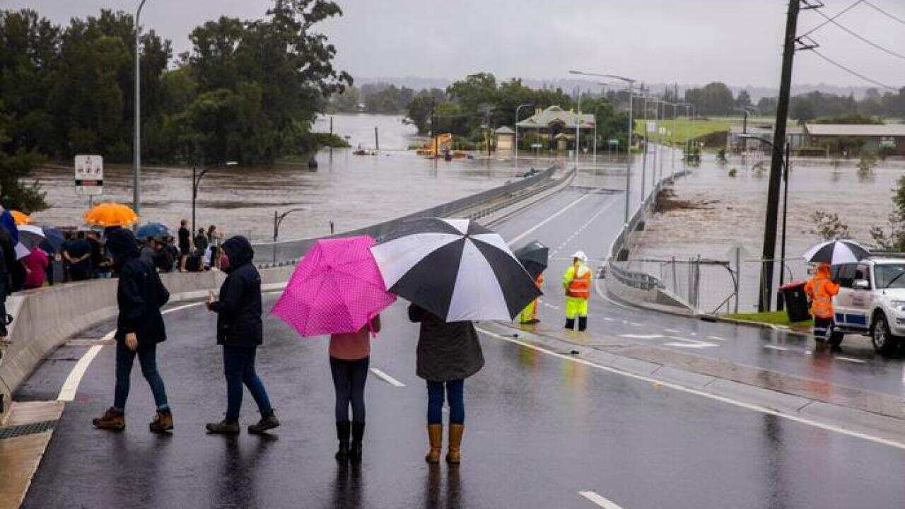 مردم در حال تماشای سیلاب روی پل جدید ویندزور بر روی دریاچه هاوکسبری، یکشنبه، ٢۱ مارچ ٢٠٢٠.