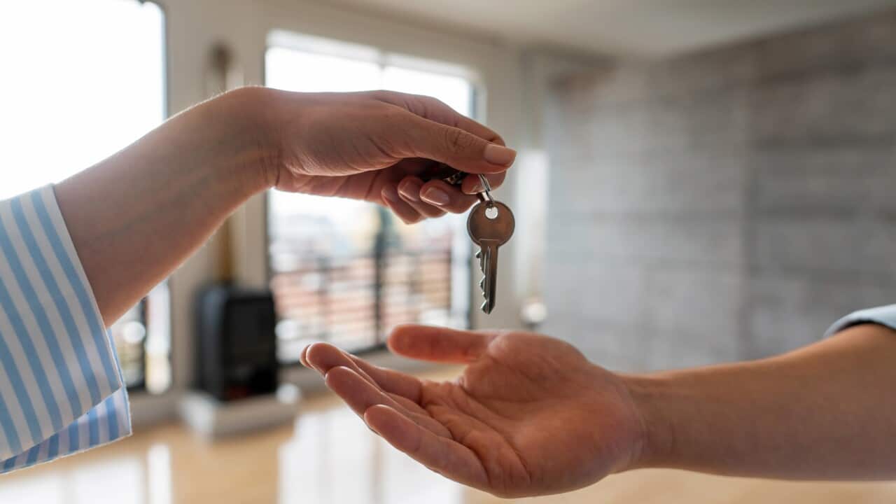 Real estate agent giving the keys of his new house to a man