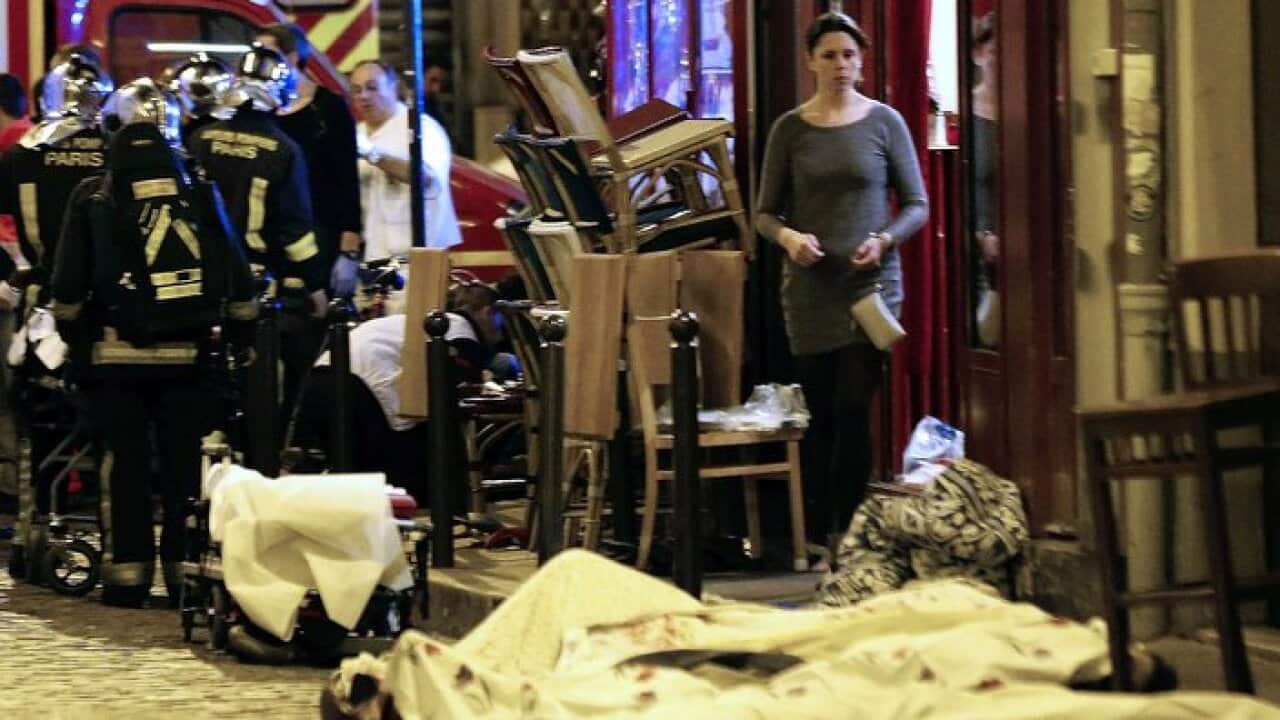 A woman watches victims in the 10th district of Paris