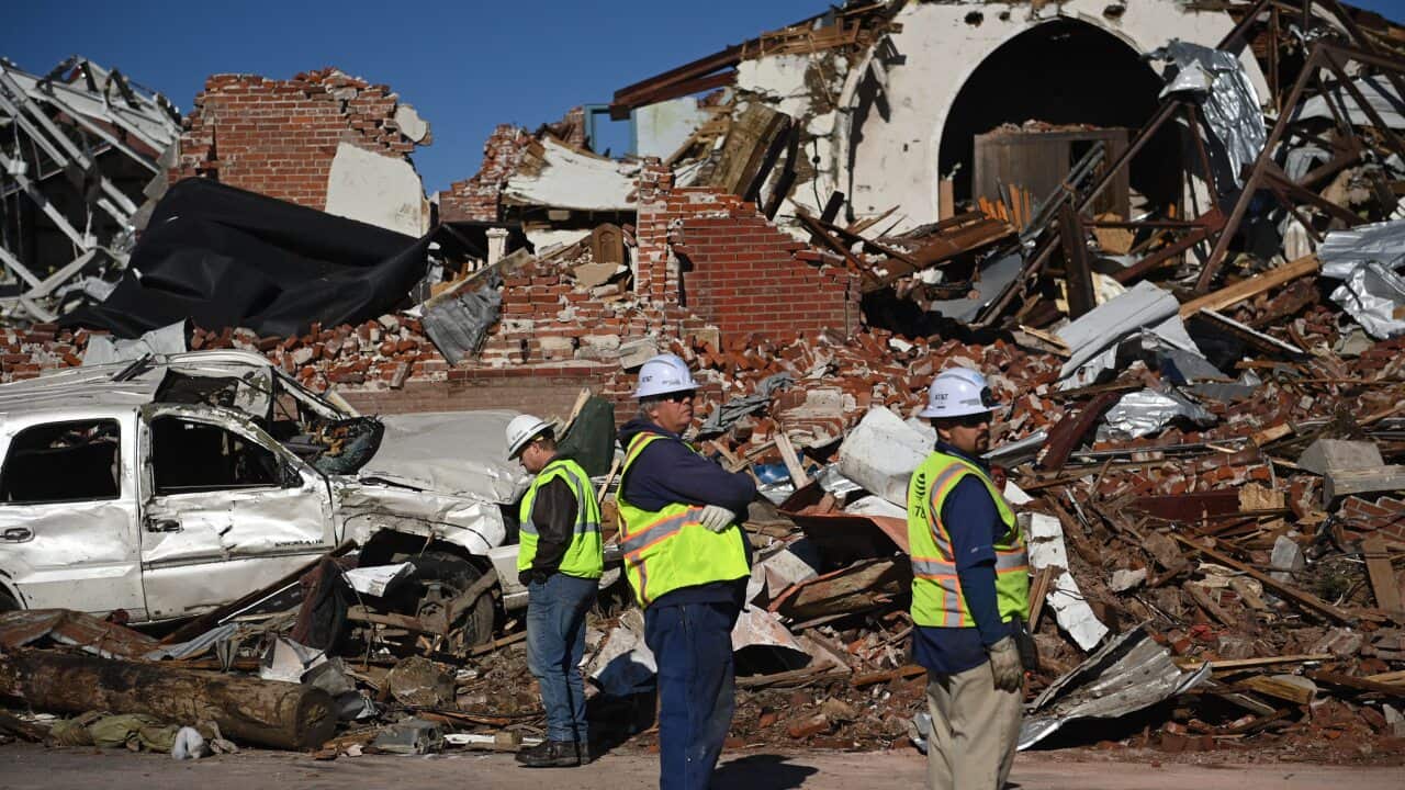 Workers survey tornado damage after extreme weather hit the region on 12 December 12.