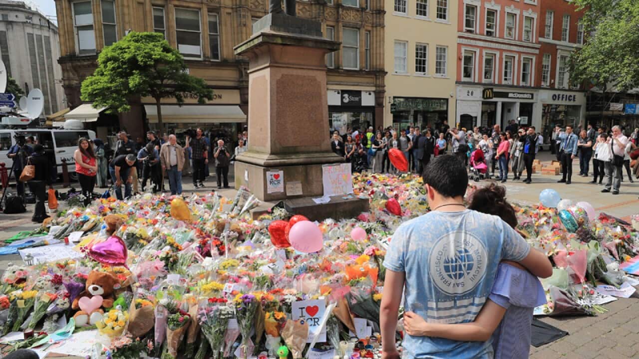 People look at flowers in St Ann's Square in Manchester