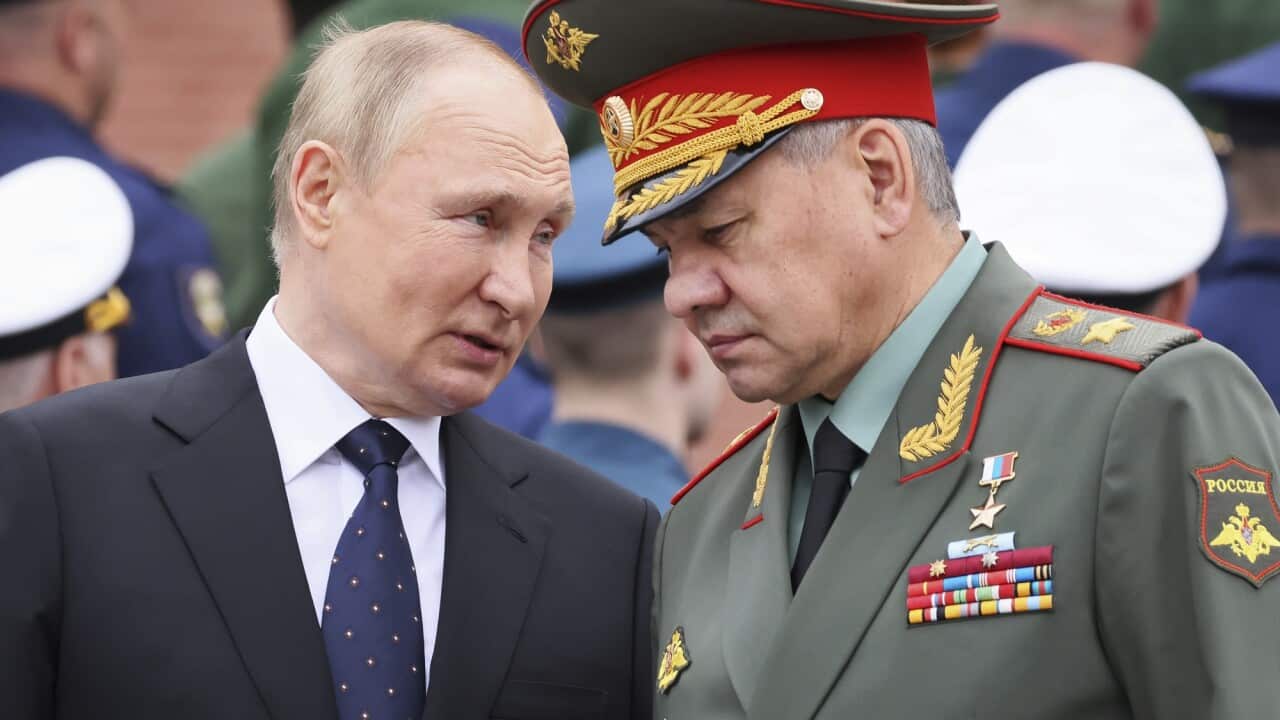 Russian President Vladimir Putin speaks with Russian Defence Minister Sergei Shoigu during a wreath laying ceremony at the Tomb of Unknown Soldier in Moscow.